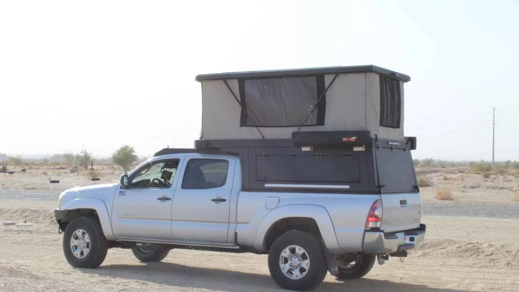 overlanding camper shell on pickup truck with pop up roof setup designed for off grid travel and rugged terrain