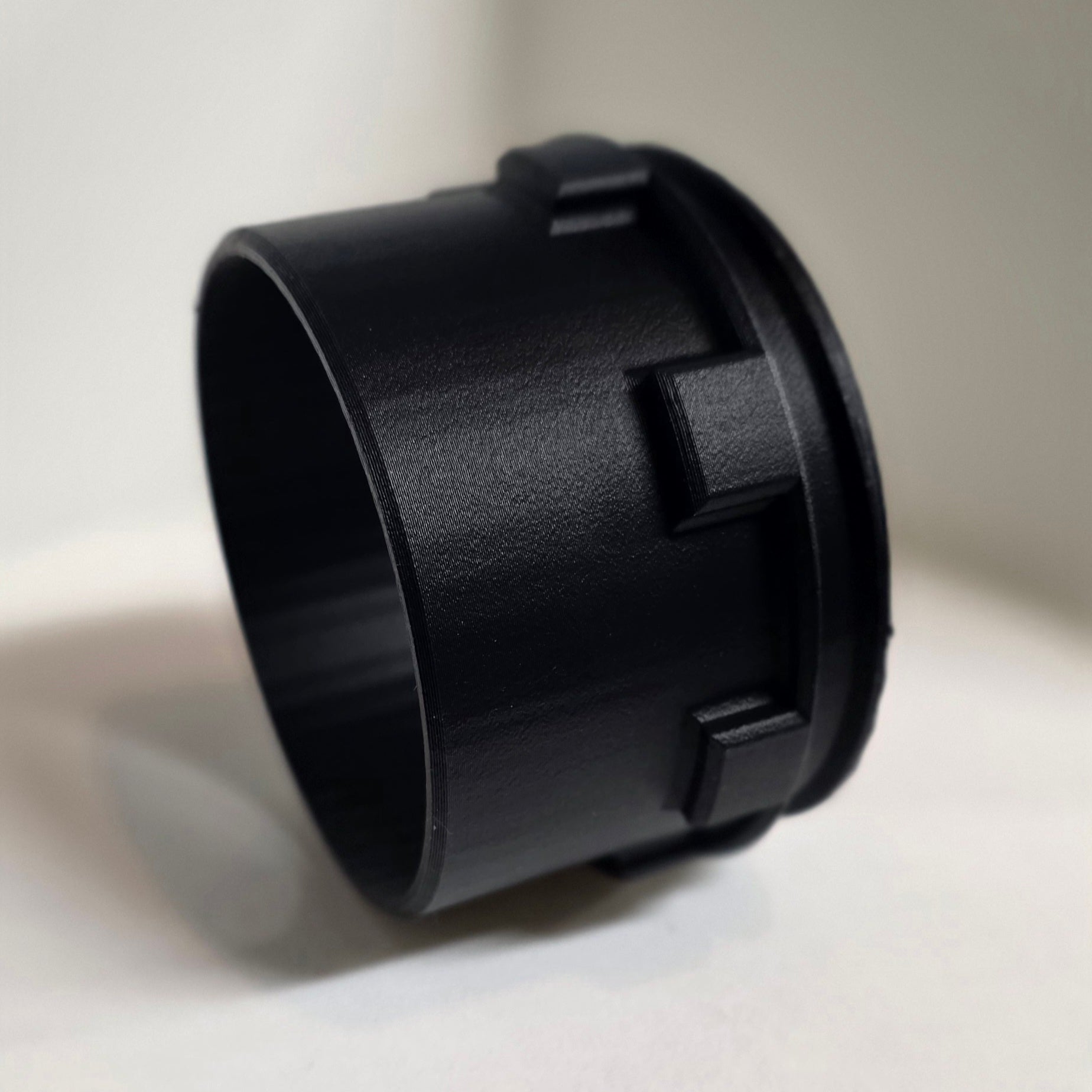 Black plastic component on a light gray background