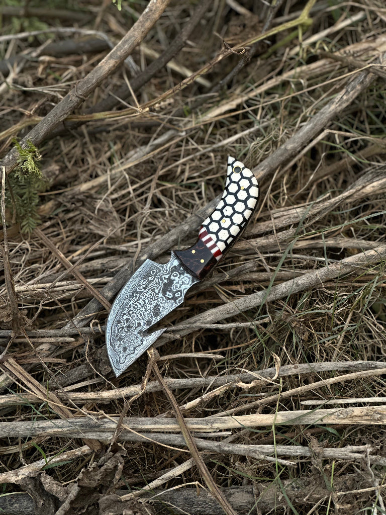 Decorative knife with a patterned handle on dry grass
