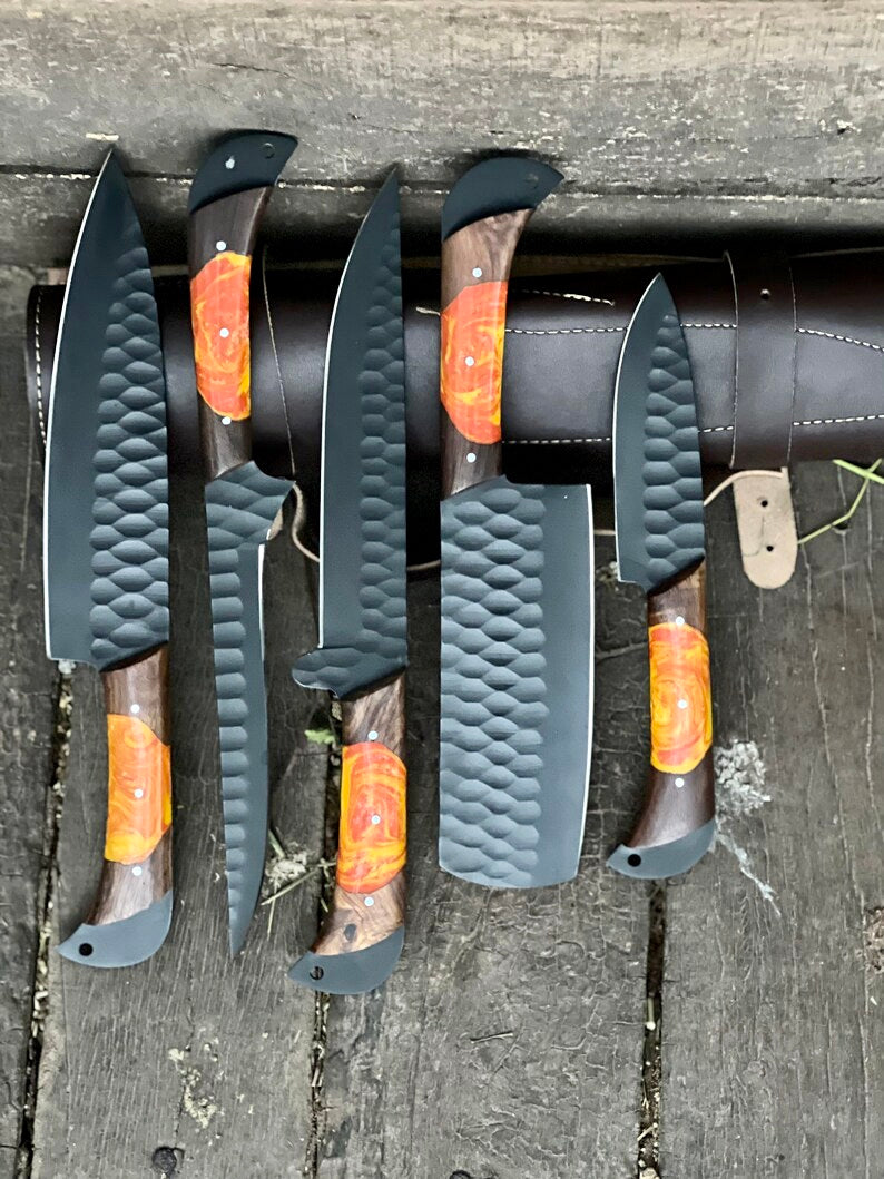 Set of knives with wooden handles and orange accents on a wooden surface