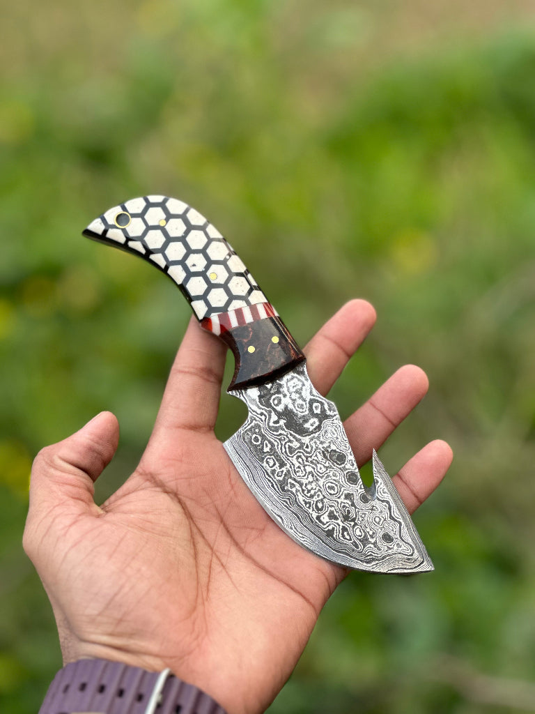 Decorative knife held in a hand with a blurred green background