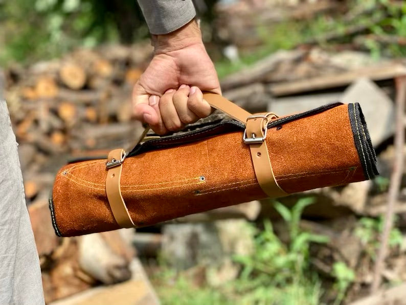 Person holding a brown leather roll with a blurred natural background