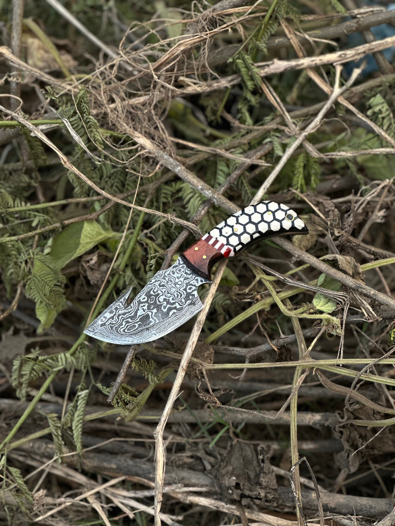 Decorative knife with a detailed blade on dry grass