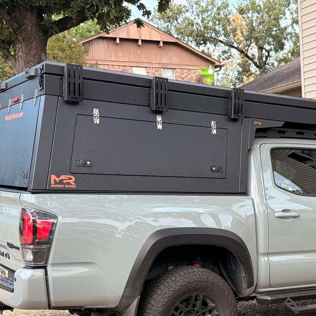 Truck bed with a black cargo management system on a gray truck, outdoors.