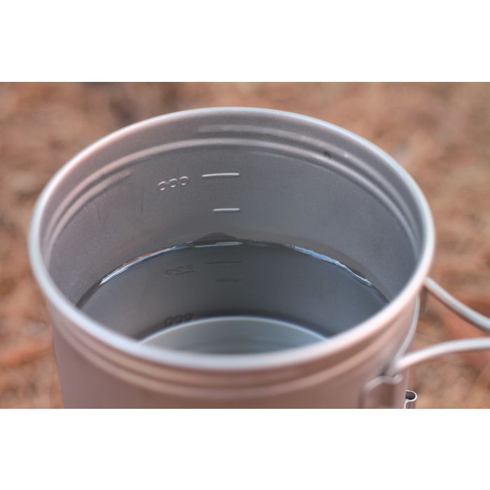 Metal cup with water on a blurred natural background