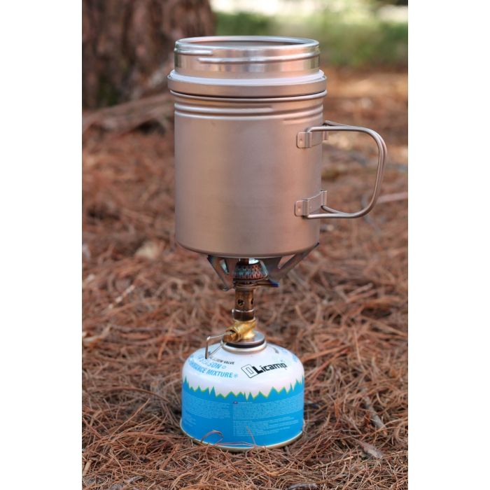 Portable camping stove with mug attachment on a natural background