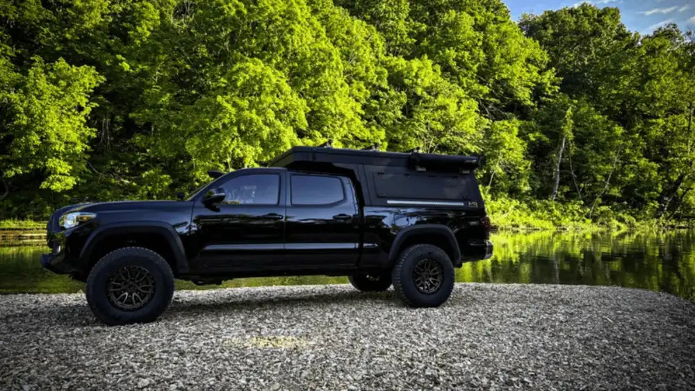 Black work truck cap mounted on pickup by lakeside, highlighting Truck Toppers for Contractors built for durability, security, and daily professional use