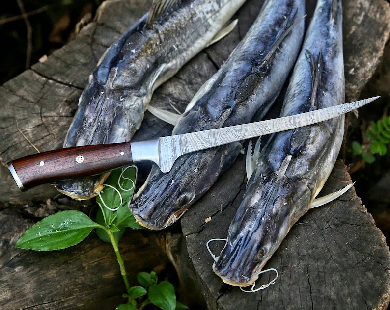 Fishing knife with wooden handle on a log with fish