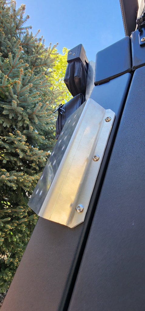 Metallic car roof rack with a clear cover against a blue sky and green trees background