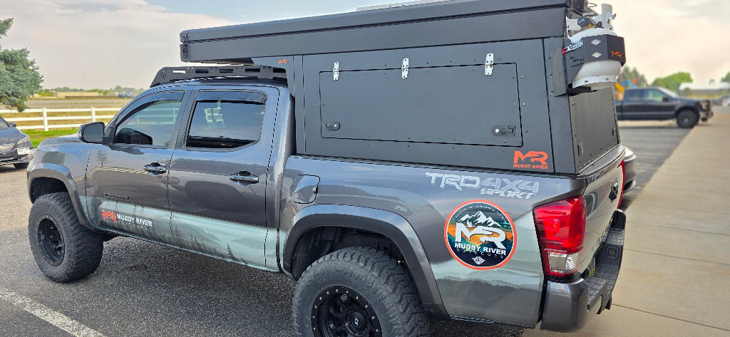 Gray Toyota truck with a custom bed cover on a road