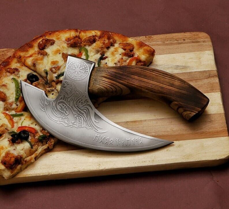 Decorative knife with wooden handle on a wooden cutting board with pizza slices