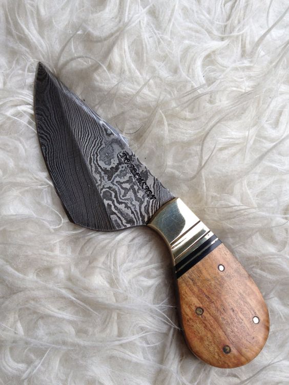 Decorative knife with a wooden handle on a textured white background