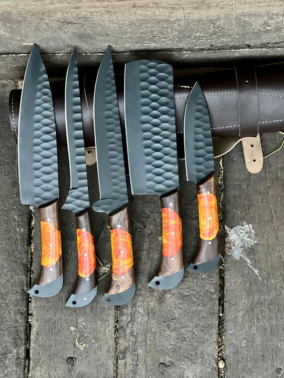 Set of five knives with textured handles on a wooden surface