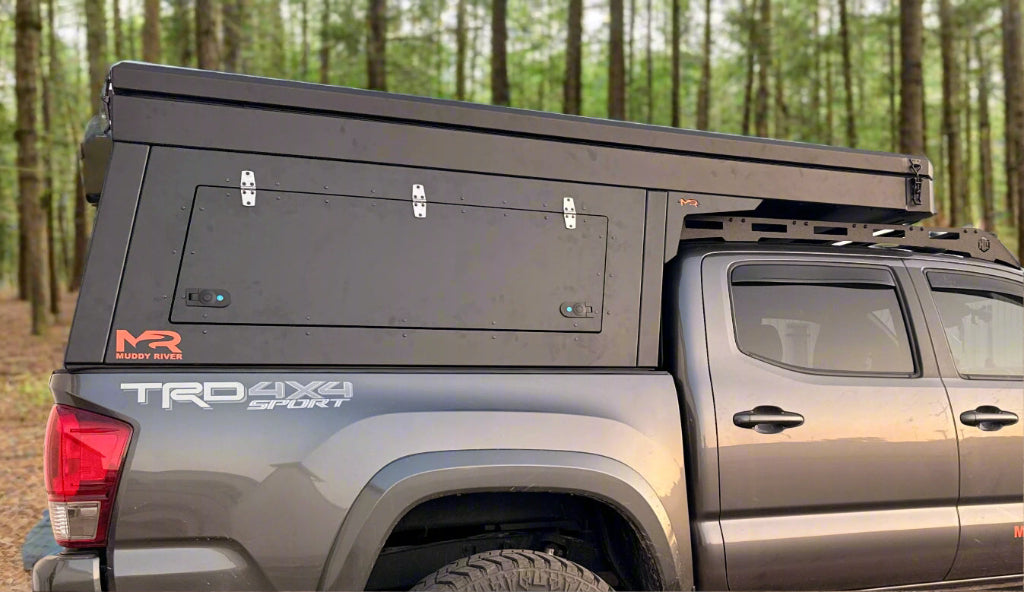 Gray Toyota truck with a black Eddy camper and 'Muddy River' branding.