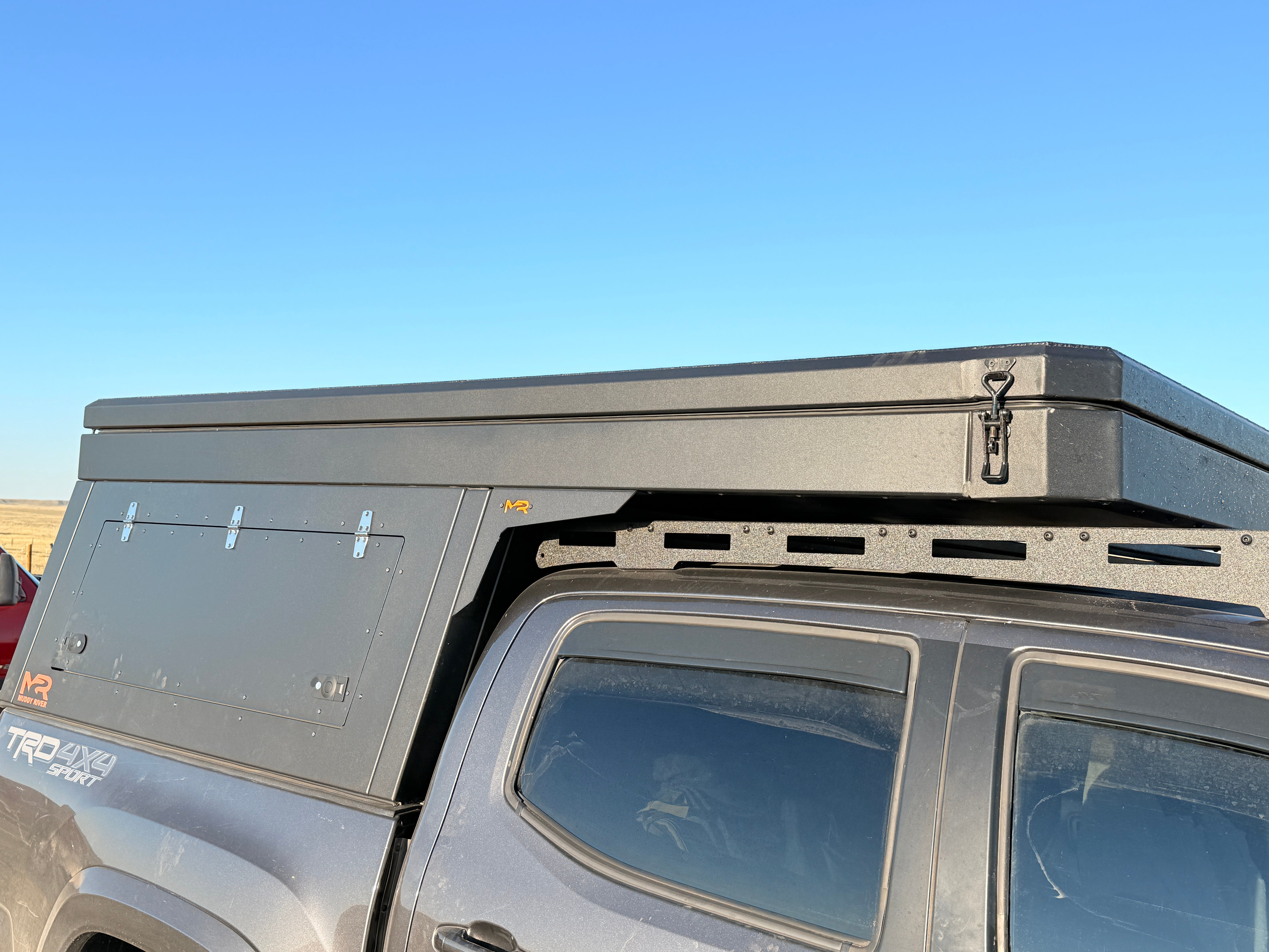 Roof box attached to a vehicle with a clear blue sky background
