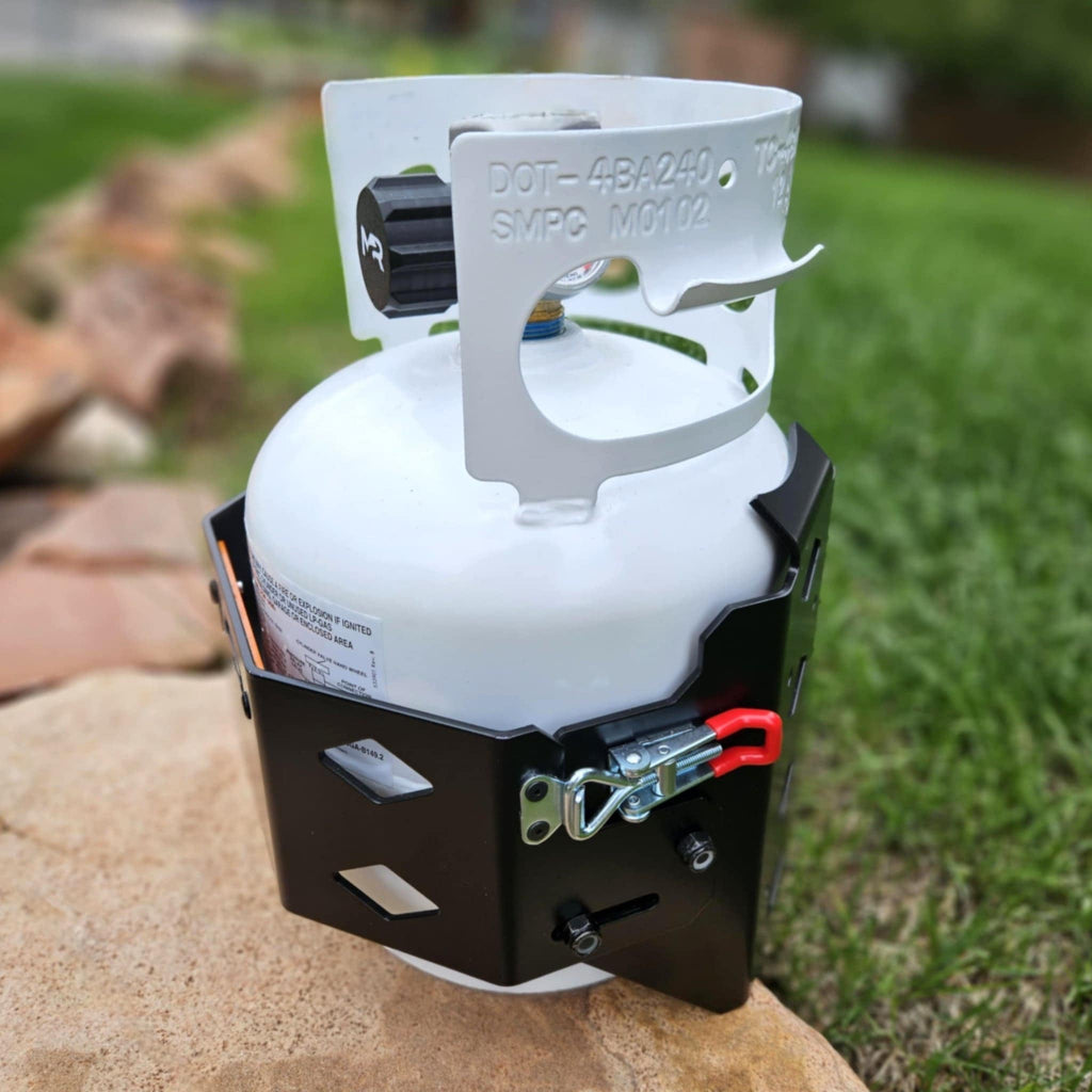 Propane tank on a rock with grass and rocks in the background