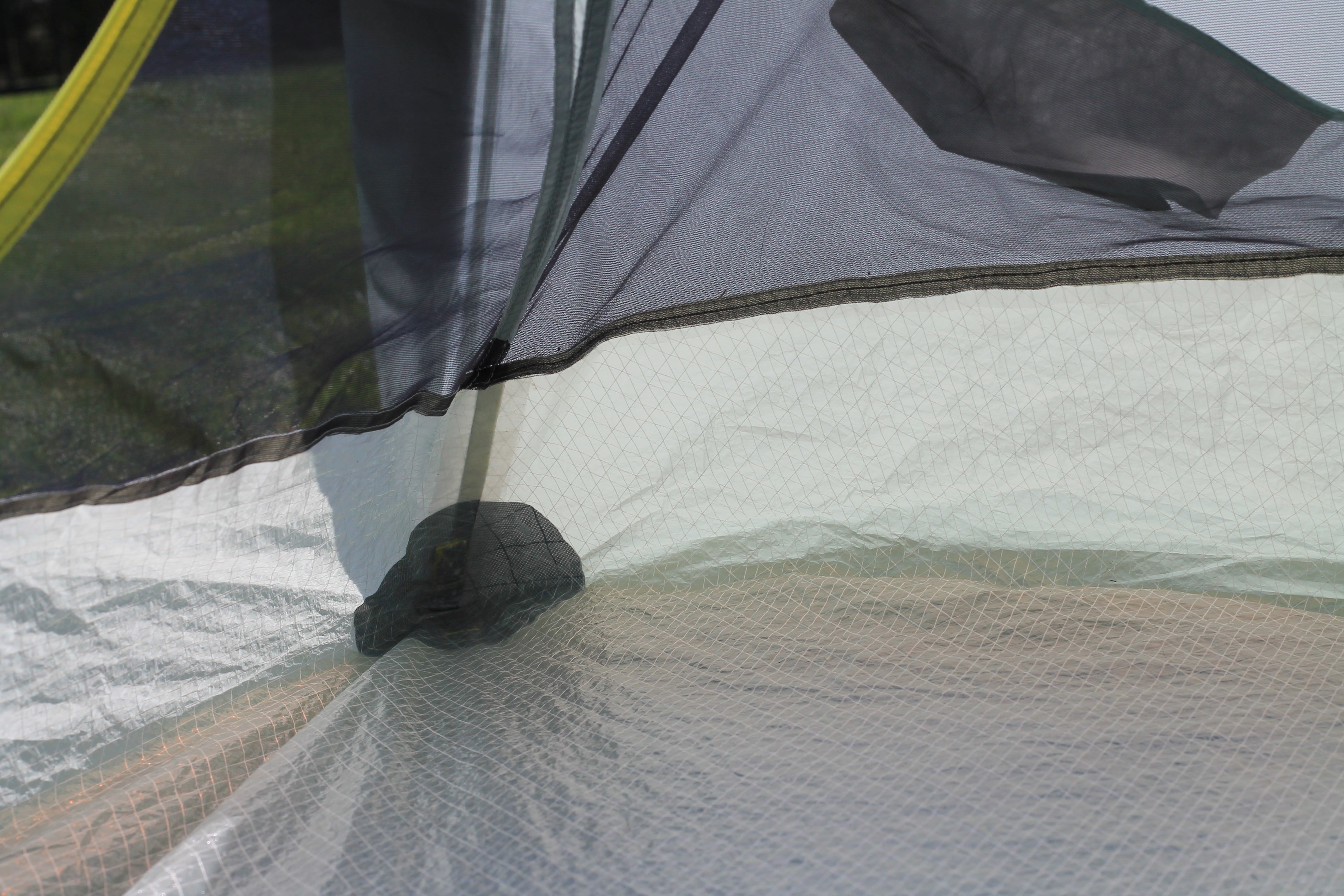 Close-up of a camping tent floor with mesh and zipper details