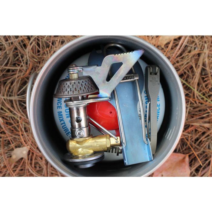 Close-up of a camping stove with accessories on a natural background